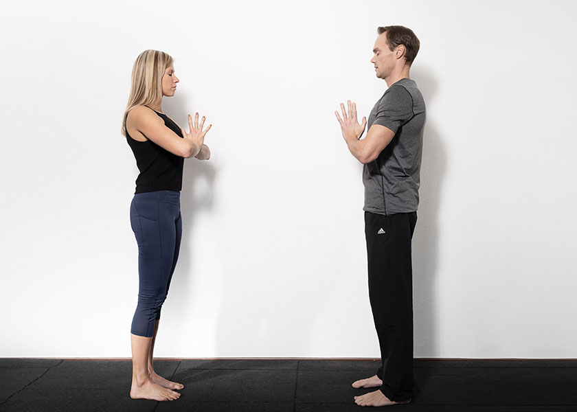 Die Trainer begrüßen sich in einer Yoga Pose
