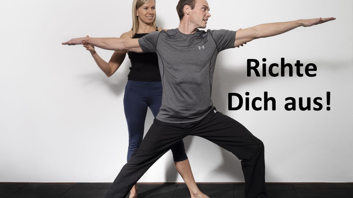 Yoga Lehrerin zeigt dem Coachee die Krieger Position