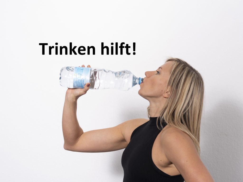 Trainerin trinkt aus einer Wasserflasche